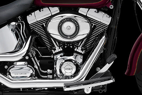 Softail Fat Boy / Harley-Davidson Styling pur:    Genieen Sie den unverwechselbaren Look des Twin Cam 103 Motors, der an seiner Herkunft keine Zweifel aufkommen lsst. Er ist voll und ganz im echten Harley-Davidson Stil gestaltet  mit einer Liebe zum Detail, die Sie bei anderen Marken vergeblich suchen werden. Die schwarzen, pulverbeschichteten Zylinderkpfe und Zylinder bilden einen prgnanten Kontrast zu den polierten Khlrippenkanten und verchromten Ventildeckeln. Ein aus Metall gefertigtes Juwel: pur und vor Kraft strotzend. Von der klassischen Linie seiner Khlrippen bis hin zu den klaren Konturen seiner Gehuse und Deckel ist der Twin Cam 103 ein rckhaltloses Bekenntnis zu allem, was die Zufriedenheit des Fahrers ausmacht.
