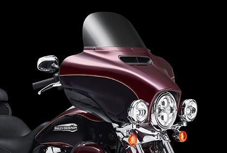 Electra Glide Ultra Classic / Neu gestaltete Verkleidung reduziert Verwirbelungen:    Um dem Fahrtwind Paroli zu bieten, zog Harley-Davidson alle Register: Strmungsmechanik und komplizierte Algorithmen auf Supercomputern sowie die Rckmeldungen von unzhligen Windkanaltests mit Fahrern im Sattel. Danach ging es fr Tausende von Meilen hinaus auf die Strae  mit echtem Fahrtwind, echtem Sturm, echtem Nieselregen und echten Wolkenbrchen. Das Ergebnis: Eine klassische und dennoch vollkommen berarbeitete Batwing Verkleidung, die fr eine sanftere Luftumstrmung sorgt und die Verwirbelungen im Kopfbereich reduziert. Der neue, auf Tastendruck zu ffnende und zu schlieende Luftkanal leistet den grten Beitrag dazu. Das Gefhl im Sattel wird noch besser.
