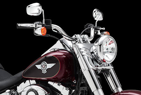 Softail Fat Boy / Fat Features:    Die silberfarbenen 17-Zoll-Scheibenrder aus Leichtmetallguss im Bullet Hole Design machen mchtig Eindruck  nicht zuletzt dank der ppigen Bereifung: Vorn rotiert ein feister 140er, am Heck ein Gummi im 200er Format. Der extrabreite Edelstahl-Lenker ruht auf verchromten Risern im Bare Knuckle Design. Selbst die Tankembleme glnzen mit einer Extraportion gleienden Chroms. Ein solches Bike zieht berall die Blicke auf sich.
