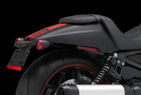 Night Rod Special / Fastback Heck:    Mit diesem coolen Heck haben die Harley-Davidson Designer der Night Rod Special einen verschrften Dragster-Look verliehen. Der radikal kurze, sich nach hinten verjngende Fender setzt den breiten Hinterreifen markant in Szene. Ein schlanker, mittiger Kennzeichenhalter sowie ein bndig integriertes LED-Rcklicht vervollstndigen das zeitlose Streamline-Design.
