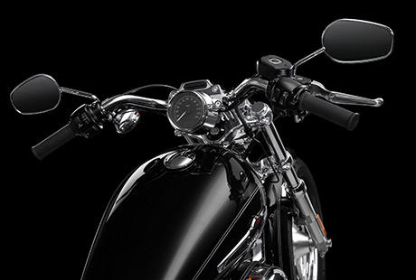 Sportster XL 1200 Custom / Pullback Lenker:    Lassen Sie sich in den Sitz sinken, und legen Sie die Hnde an die Lenkergriffe. Die Sportster 1200 Custom ist mit einem Pullback Lenker ausgestattet, der Sie in eine komfortable Cruising-Position versetzt. Wir haben ihn aus Edelstahl gefertigt und so gekrpft, dass er ihrem Krper etwa zweieinhalb Zentimeter nher kommt. Fr eine entspannte Fahrt dem Horizont entgegen.
