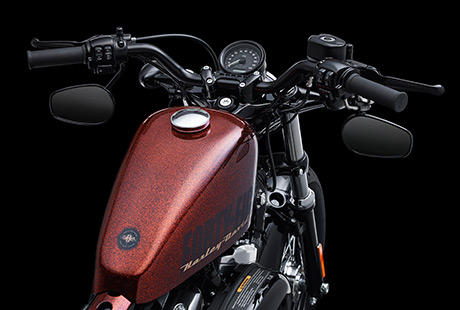 Sportster Forty-Eigth / Cooler Lenker, klassischer Tacho und unter dem Lenker montierte Spiegel:    Der niedrige schwarze Drag Bar Lenker mit Tachometer und nach unten ausgerichteten Spiegeln betont den puristischen, minimalistischen Look der Forty-Eight. Der Drag Bar Lenker wurde von den Hot-Rod-Pionieren vergangener Zeiten inspiriert. Er ist Ausdruck des Old-School-Stylings und gestattet dem Fahrer eine extracoole Sitzposition.
