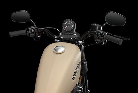 Sportster XL 883 Iron / Drag Bar Lenker:    Der flache schwarze Drag-Style-Lenker und die schwarzen Griffe unterstreichen den Custom-Look der Iron 883. Der Lenker, dessen Form dem Drag Strip entstammt, ist ein Old-School-Feature, das dem Fahrer eine dezent nach vorn geneigte Sitzposition beschert.
