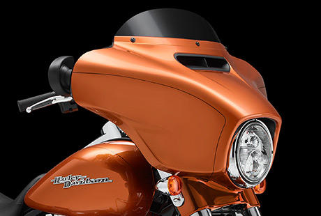 Street Glide Special / Die Verkleidung minimiert Helmturbulenzen:    So optimiert Harley-Davidson die Aerodynamik: Strmungsmechanik, Algorithmen, Hochgeschwindigkeits-Supercomputer und Abertausende von Windkanal-Tests mit echten Bikern im Sattel, die uns ihre Eindrcke schildern. Und all das, bevor wir auf der Strae Tausende von Kilometern mit realen Windben und echtem Regen zurckgelegt haben. Das Ergebnis: Eine Batwing-Verkleidung, die fr einen gleichmigeren Luftstrom brgt und Helmturbulenzen minimiert. Das leistet zum groen Teil der Druckausgleich durch den Strmungskanal an der Front. Er lsst sich mit einem Tastendruck ffnen und schlieen. Der Fahrkomfort ist nochmals sprbar gewachsen.
