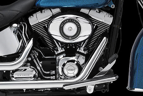 Softail Deluxe / Schwarze Zylinderkpfe und Zylinder mit polierten Khlrippenkanten und verchromten Ventildeckeln:    Genieen Sie den unverwechselbaren Look des Twin Cam 103 Motors, der an seiner Herkunft keine Zweifel aufkommen lsst. Er ist voll und ganz im echten Harley-Davidson Stil gestaltet  mit einer Liebe zum Detail, die Sie bei anderen Marken vergeblich suchen werden. Die schwarzen, pulverbeschichteten Zylinderkpfe und Zylinder bilden einen prgnanten Kontrast zu den polierten Khlrippenkanten und verchromten Ventildeckeln. Ein aus Metall gefertigtes Juwel: pur und vor Kraft strotzend. Von der klassischen Linie seiner Khlrippen bis hin zu den klaren Konturen seiner Gehuse und Deckel ist der Twin Cam 103 ein rckhaltloses Bekenntnis zu allem, was die Zufriedenheit des Fahrers ausmacht.
