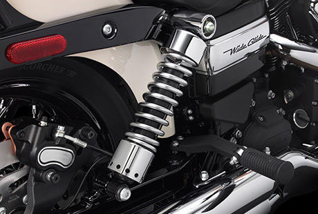 Dyna Wide Glide / Einstellbare Federbeine:    Die Vorspannung lsst sich ganz einfach mit einem Schraubenschlssel einstellen, um den Charakter des Fahrwerks exakt an Beladung und Fahrstil sowie Ihre Ansprche anzupassen. Das am Heck tief liegende Fahrwerk sorgt fr eine ebenso lssige wie angenehme Sitzposition. Schwingen Sie sich in den niedrigen Sattel, und genieen Sie ganz entspannt Ihre Hausstrecke.
