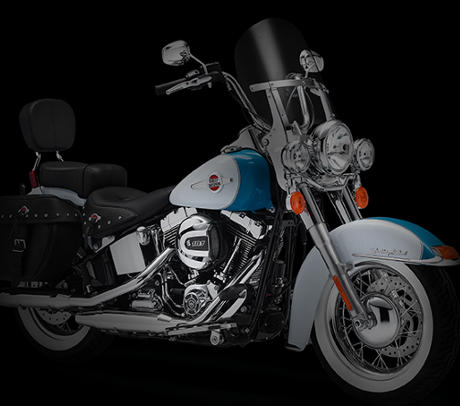 Softail Heritage Classic / Nostalgisches Custom-Design:    Spielen Speichenrder, wuchtige Reifen und nietenbeschlagenes Leder eine Rolle dabei, wie sich ein Bike auf der Strae anfhlt? Natrlich! Es sind solche Extras, die die Heritage Softail Classic zum ultimativen Boulevard-Cruiser machen. Als Rallys in den 40-er Jahren immer populrer wurden, konnte man auf Events wie der Daytona Bike Week sicher sein, neuen Stilrichtungen zu begegnen  Motorrdern wie diesem! Werfen Sie einen Blick auf die Satteltaschen mit ihren versteckten Komfortverschlssen, die direkt dieser goldenen ra entstammen knnten. Betrachten Sie die Fender  wuchtig und stromlinienfrmig gestaltet und mit hochwertigem Lack und verchromten Akzenten veredelt. Spiegeln Sie sich im Chrom des eindrucksvollen 21-Zoll-Scheinwerfers und genieen Sie den Anblick der klassischen Drahtspeichenrder mit ihren breiten Reifen.
