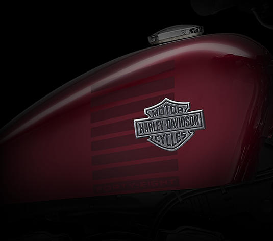 Sportster Forty-Eight / Klassischer Peanut-Tank mit neuem Emblem:    Der kleine, 7,9 Liter fassende Peanut-Kraftstofftank feierte seine Premiere an einem Harley-Davidson Motorrad im Jahr 1948  von dieser Jahreszahl wurde auch der Modellname der Forty-Eight abgeleitet. Und noch heute erfreut sich das megaklassische Harley-Davidson Tankstyling ungebrochener Beliebtheit. Mit seiner niedrigen, kompakten Form lenkt der Tank den Blick unweigerlich auf den wuchtigen Motor und die klare Linie des Sportster Rahmens. Wir haben ihn mittels eines gewichtsreduzierten Metallstreifens auf den Rahmen gesetzt und mit lebendigen Graphics und einem 3D-Metallemblem so richtig in Szene gesetzt. Die perfekte Kombination von Charakter und Look.
