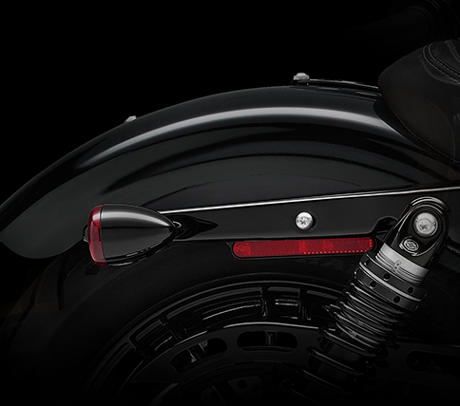 Sportster Forty-Eight / Schnrkelloses Heckdesign:    Bei einem eleganten Heckdesign zhlt jedes Detail. Kein Bedarf fr berflssigen Zierrat. Dank der Blinker mit integrierten Rck- und Bremsleuchten bleibt der Heckfender vllig frei von allen Anbauteilen  ein schnrkelloser Custom-Look. Modernste LED-Technik gestattet es, im klassischen Bullet-Gehuse gleich alle drei Lichtfunktionen unterzubringen.
