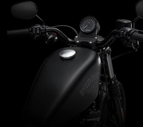 Sportster XL 883 Iron / Drag Bar Lenker:    Der flache schwarze Drag-Style-Lenker und die schwarzen Griffe unterstreichen den Custom-Look der Iron 883. Der Lenker, dessen Form dem Drag Strip entstammt, ist ein Old-School-Feature, das dem Fahrer eine dezent nach vorn geneigte Sitzposition beschert.
